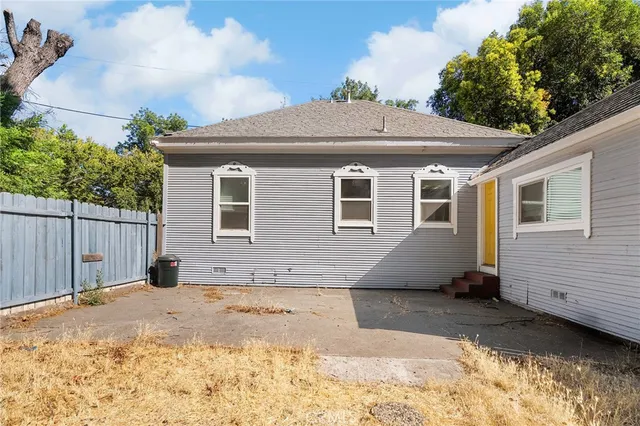 a view of backyard with wooden fence and a large tree