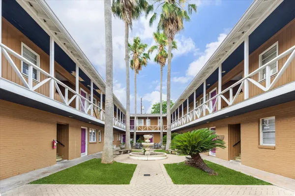 a view of a building with a yard and potted plants