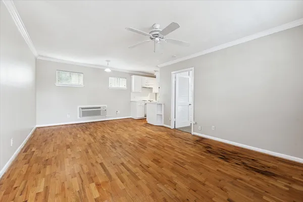 a view of empty room with wooden floor and ceiling fan