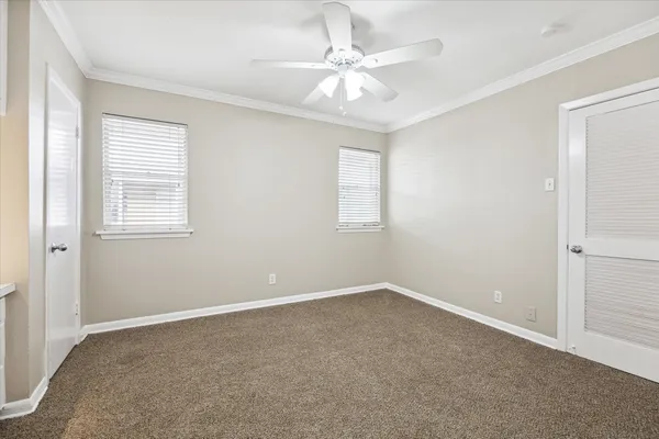 an empty room with windows and fan