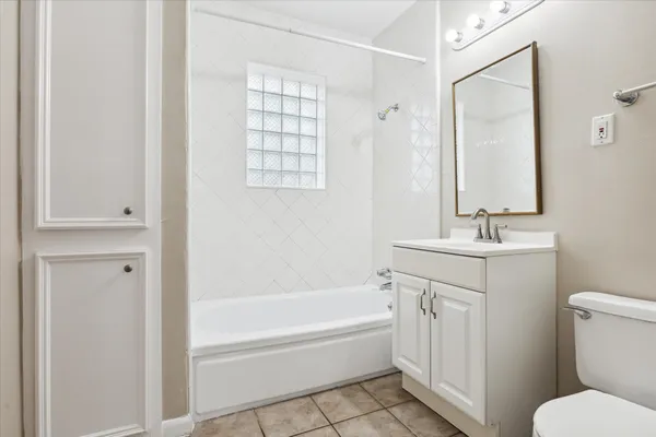a bathroom with a granite countertop sink a toilet and shower