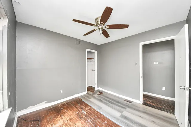 a bedroom with a bed and a ceiling fan