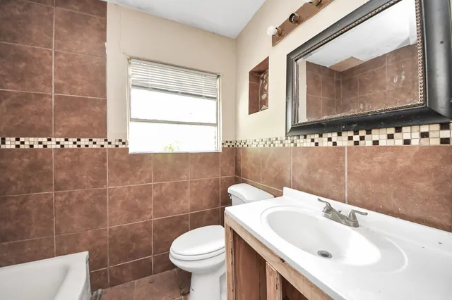 a bathroom with a sink a toilet and mirror