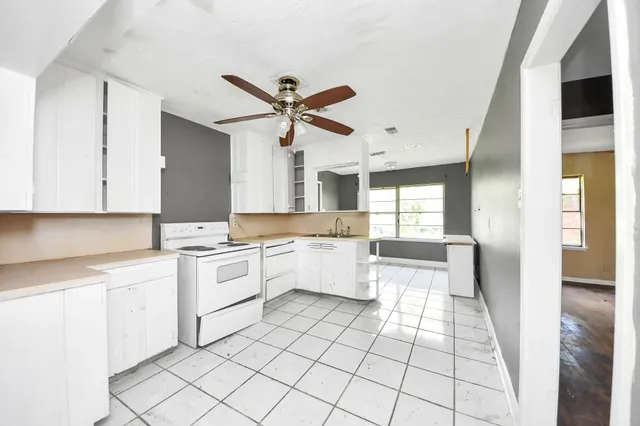 a large white kitchen with a stove a sink dishwasher and a refrigerator