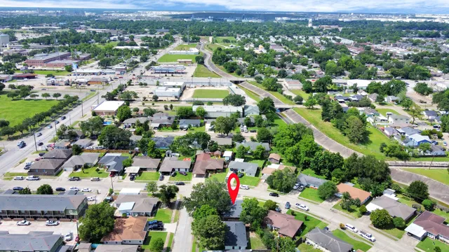an aerial view of residential houses with outdoor space and trees