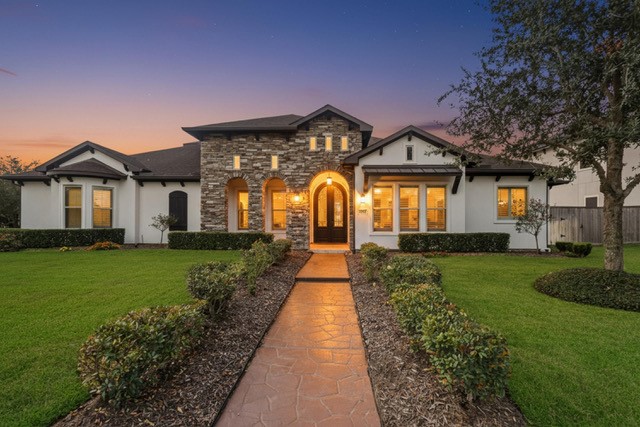 a front view of a house with a garden and yard