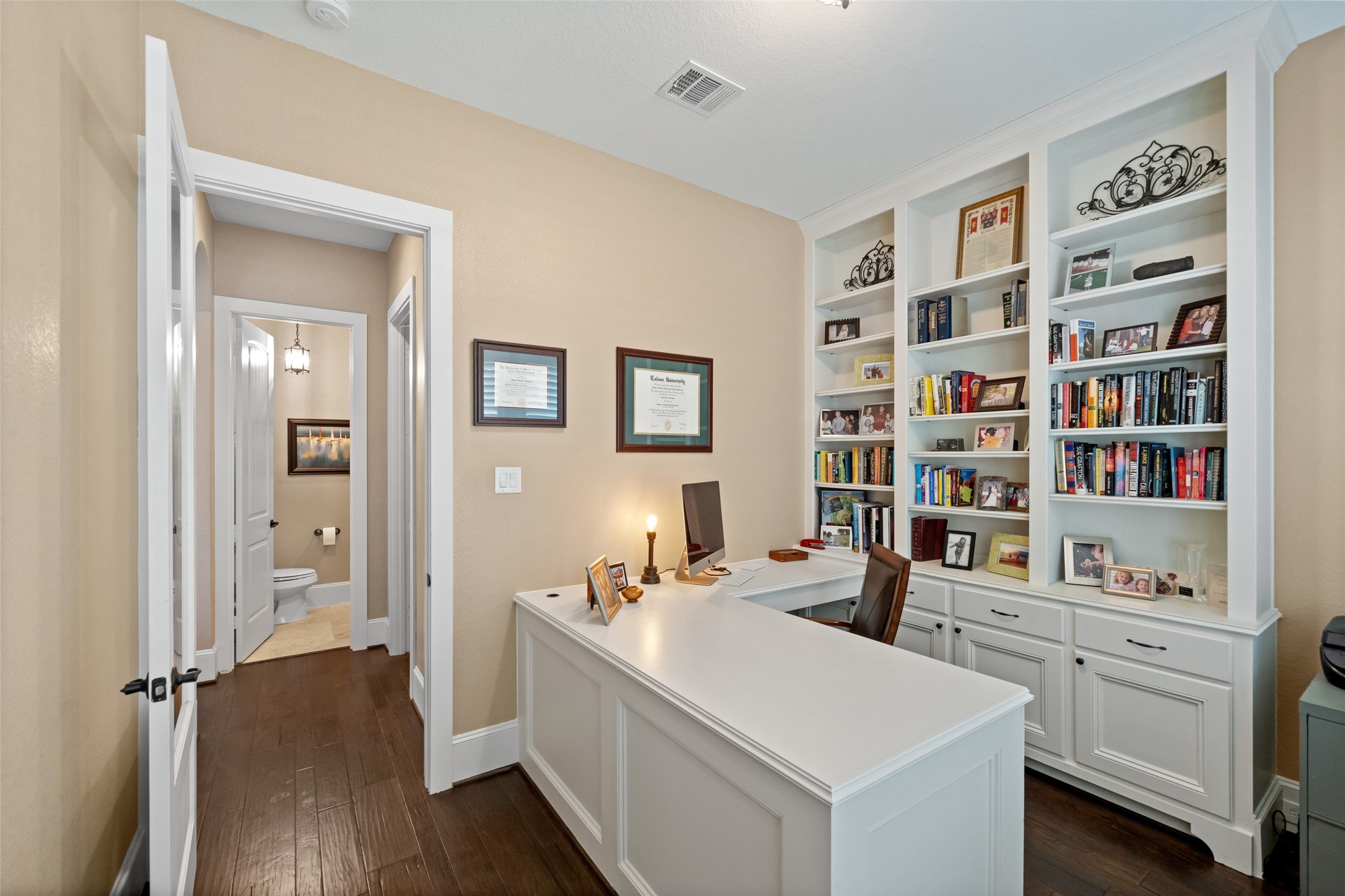 1702 Hunters Trail Friendswood, TX 77546 - Photo 28 of 42 a room with a book shelf and a wooden floor