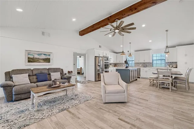 a living room with furniture and kitchen view