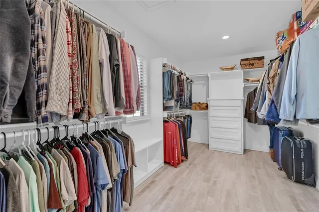 a view of walk in closet with clothes