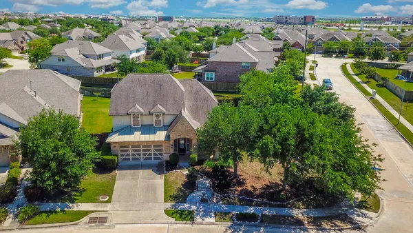 an aerial view of a house with a garden and lake view