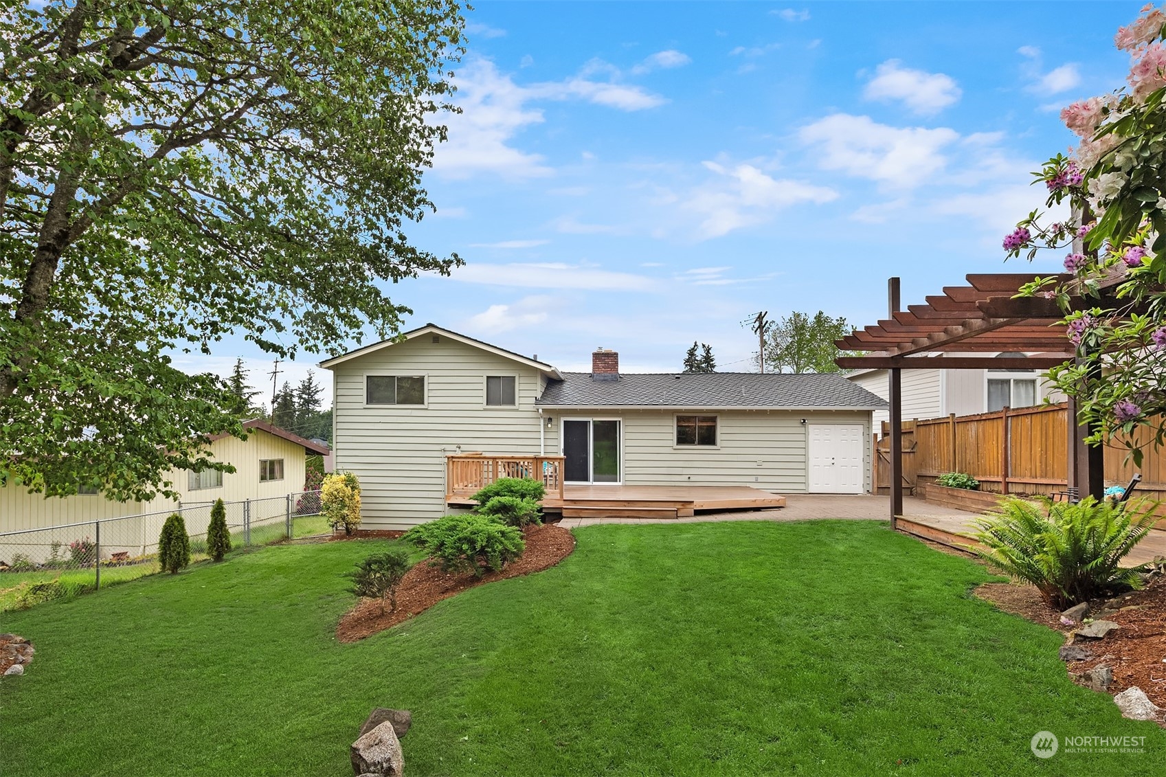 1909 Northeast 24th Street Renton, WA 98056 - Photo 28 of 34 a front view of a house with a yard and trees