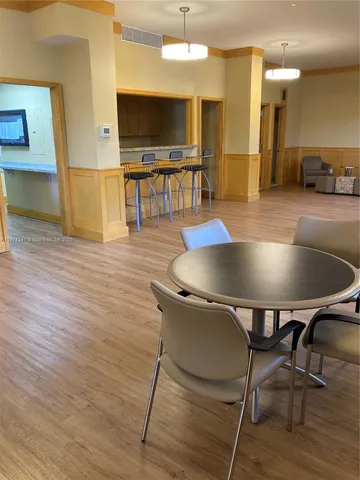 a living room with a couch and dresser with wooden floor