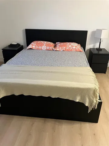 a bedroom with a bed and a night stand