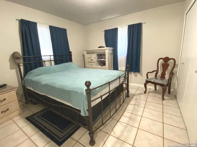 a bed sitting in a spacious bedroom next to a window