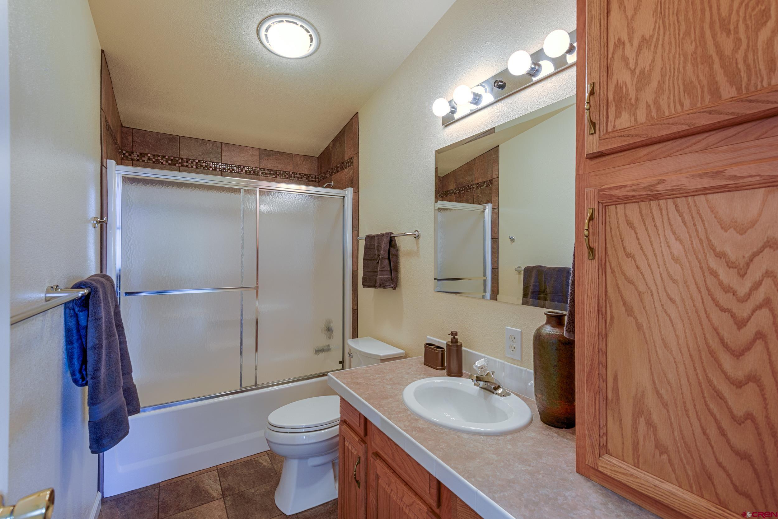 61928 Jay Jay Road Montrose, CO 81401 - Photo 18 of 36 a bathroom with a granite countertop sink toilet and shower