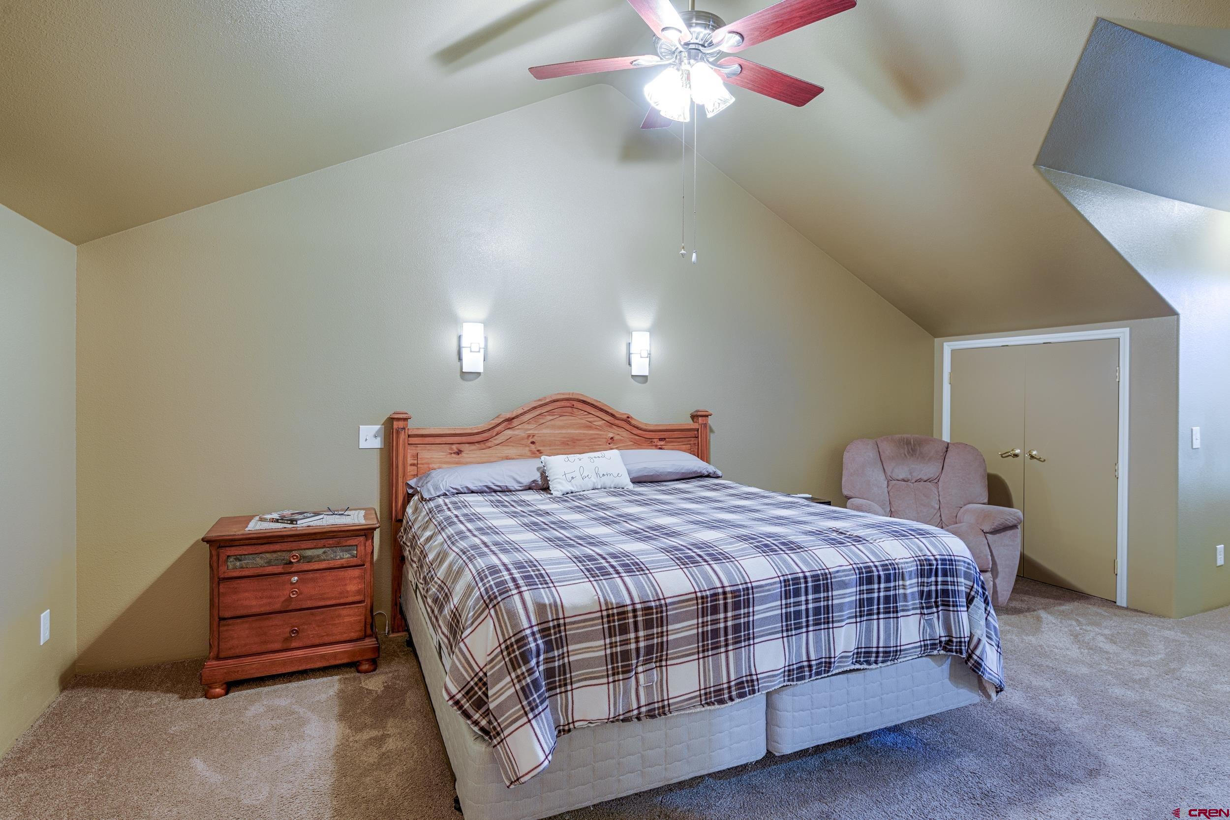 61928 Jay Jay Road Montrose, CO 81401 - Photo 19 of 36 a bedroom with a bed and a chandelier