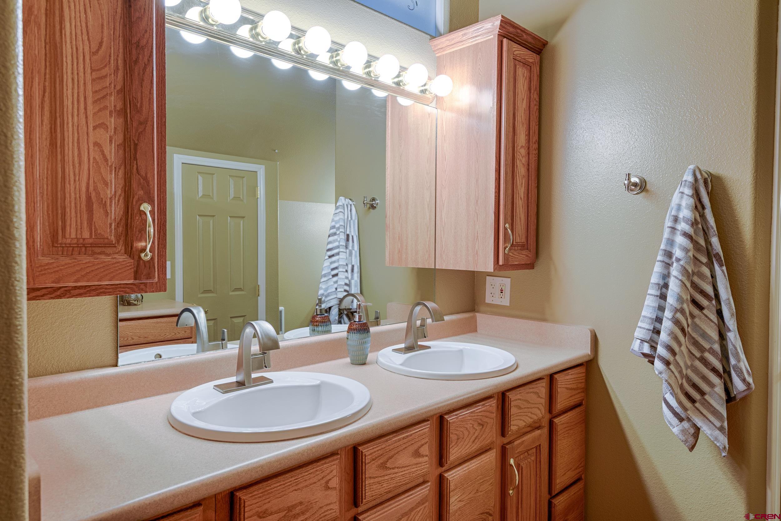 61928 Jay Jay Road Montrose, CO 81401 - Photo 22 of 36 a bathroom with a double vanity sink and a mirror