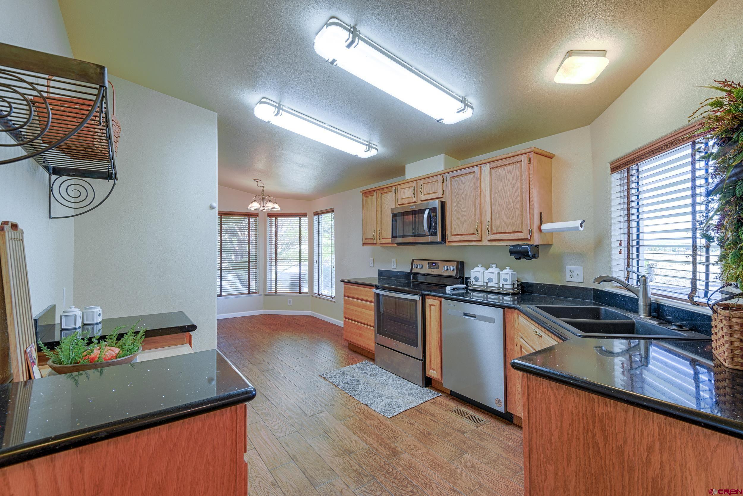 61928 Jay Jay Road Montrose, CO 81401 - Photo 7 of 36 a kitchen with stainless steel appliances granite countertop sink stove top oven and cabinets