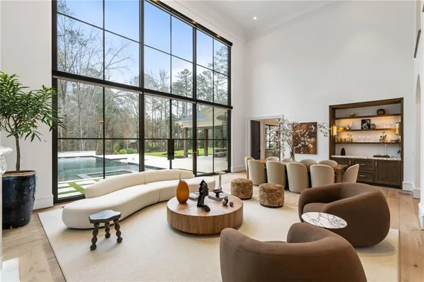 a living room with furniture and a large mirror with potted plants