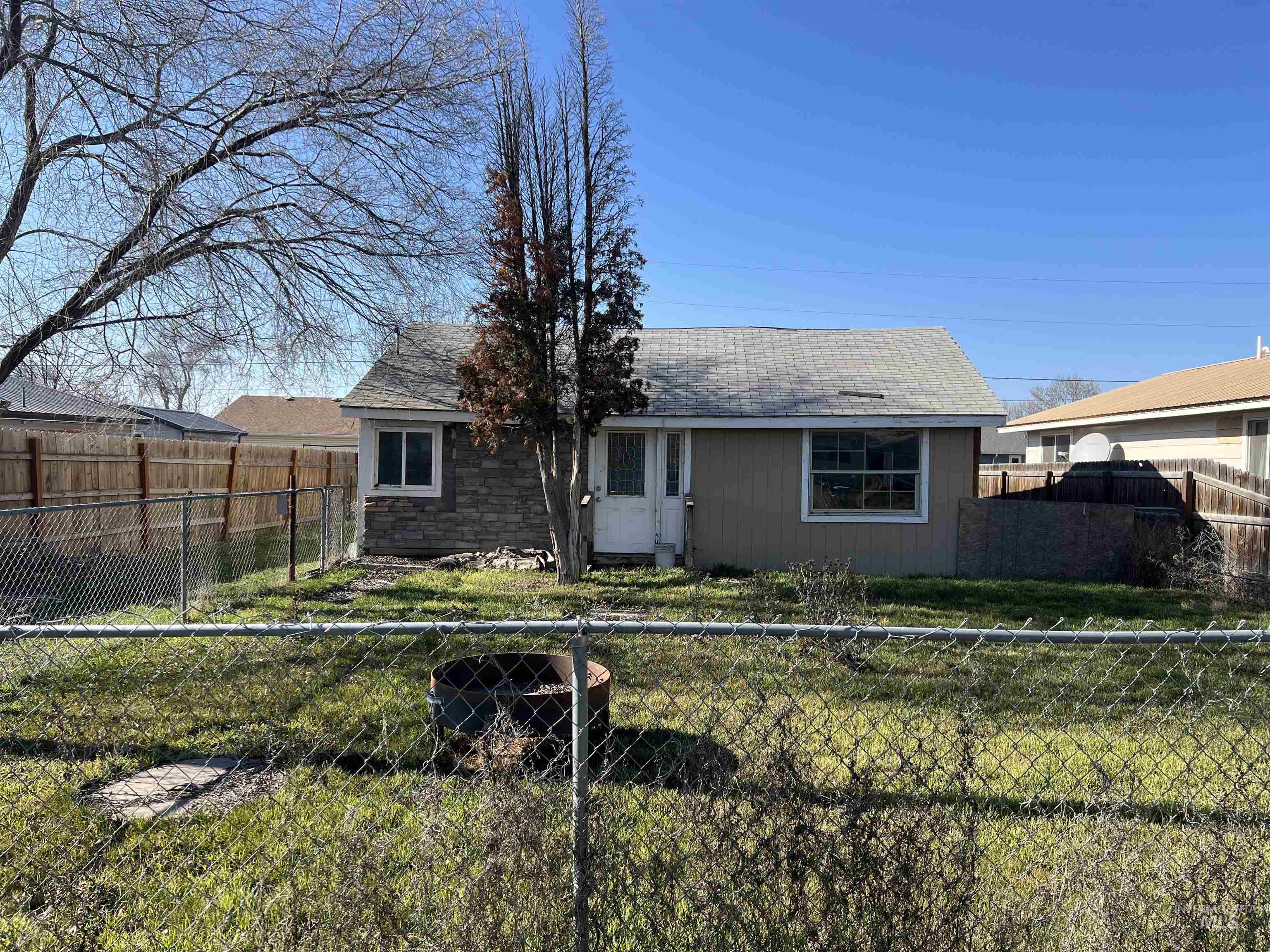 View of front facade featuring roof with shingles and a fenced backyard