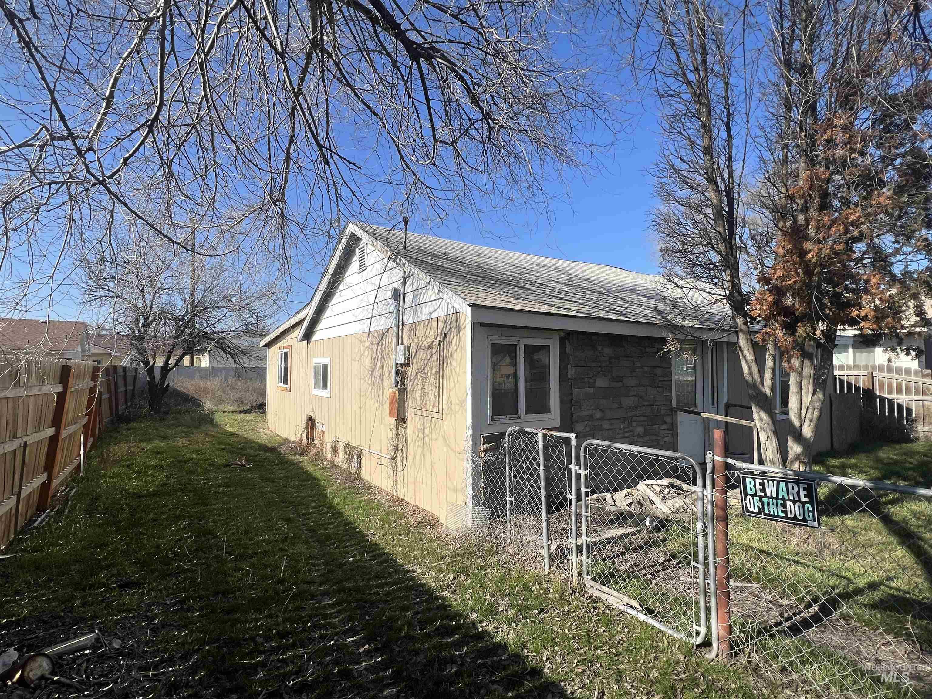 717 North 3rd Street Nyssa, OR 97913 - Photo 3 of 12 View of side of home with a gate and a shingled roof