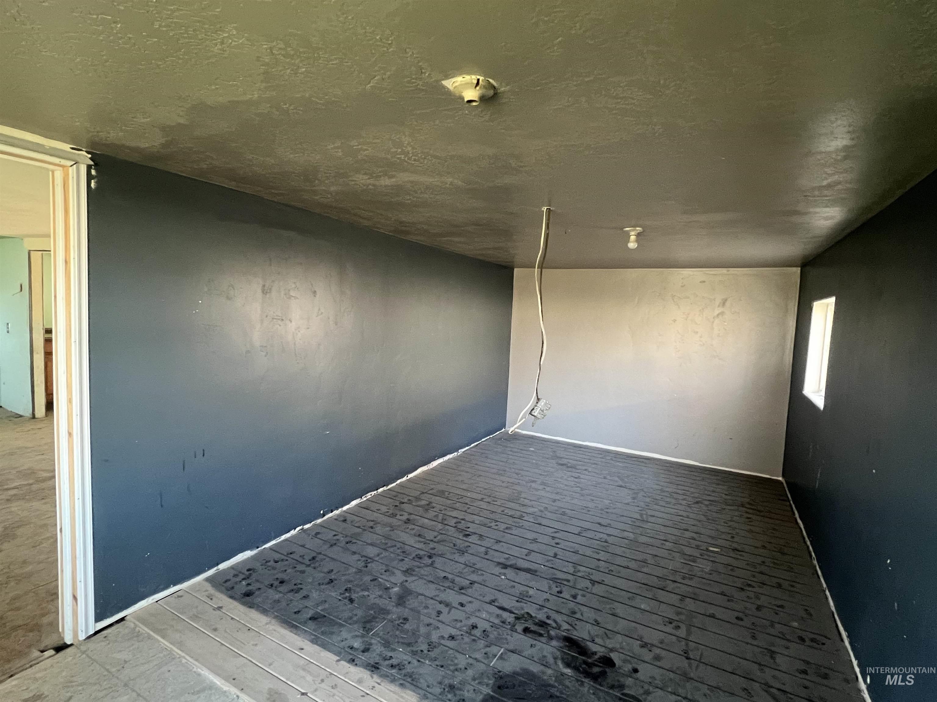 717 North 3rd Street Nyssa, OR 97913 - Photo 5 of 12 Empty room with hardwood / wood-style flooring and a textured ceiling