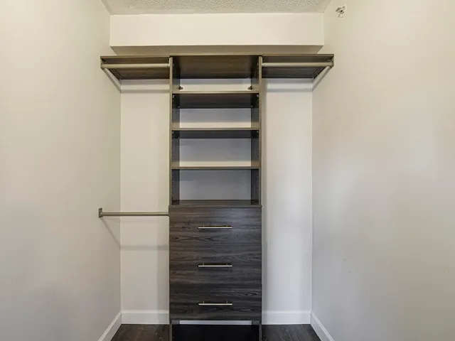 a view of walk in closet with empty racks