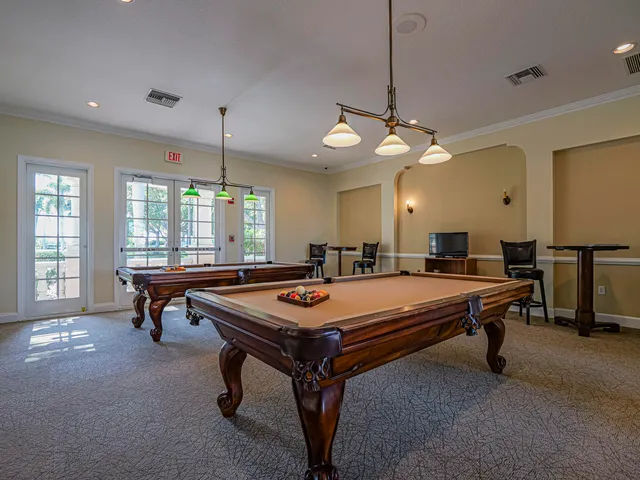 a room with pool tables and windows