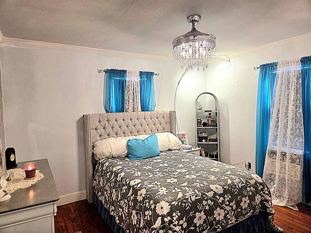 313 King Street Eden, TX 76837 - Photo 11 of 24 a bedroom with a large bed and a chandelier