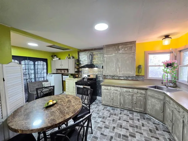 a large kitchen with a table and chairs