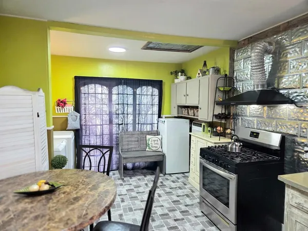 a kitchen with a stove a refrigerator and wooden floor