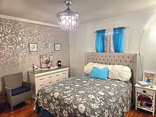 a bedroom with a large bed and a chandelier