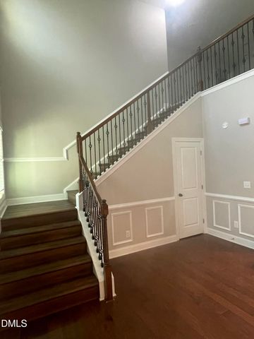 a kitchen with kitchen island granite countertop a dining table chairs refrigerator and microwave