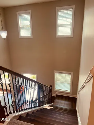 a open kitchen with stainless steel appliances granite countertop a sink dishwasher a refrigerator and a dining table with wooden floor