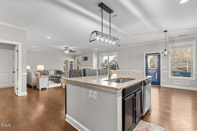 a large white kitchen with living room and couches chair