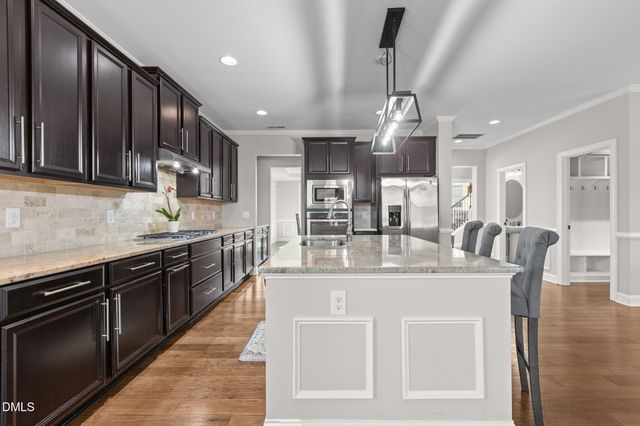 a view of an empty room with wooden floor and windows
