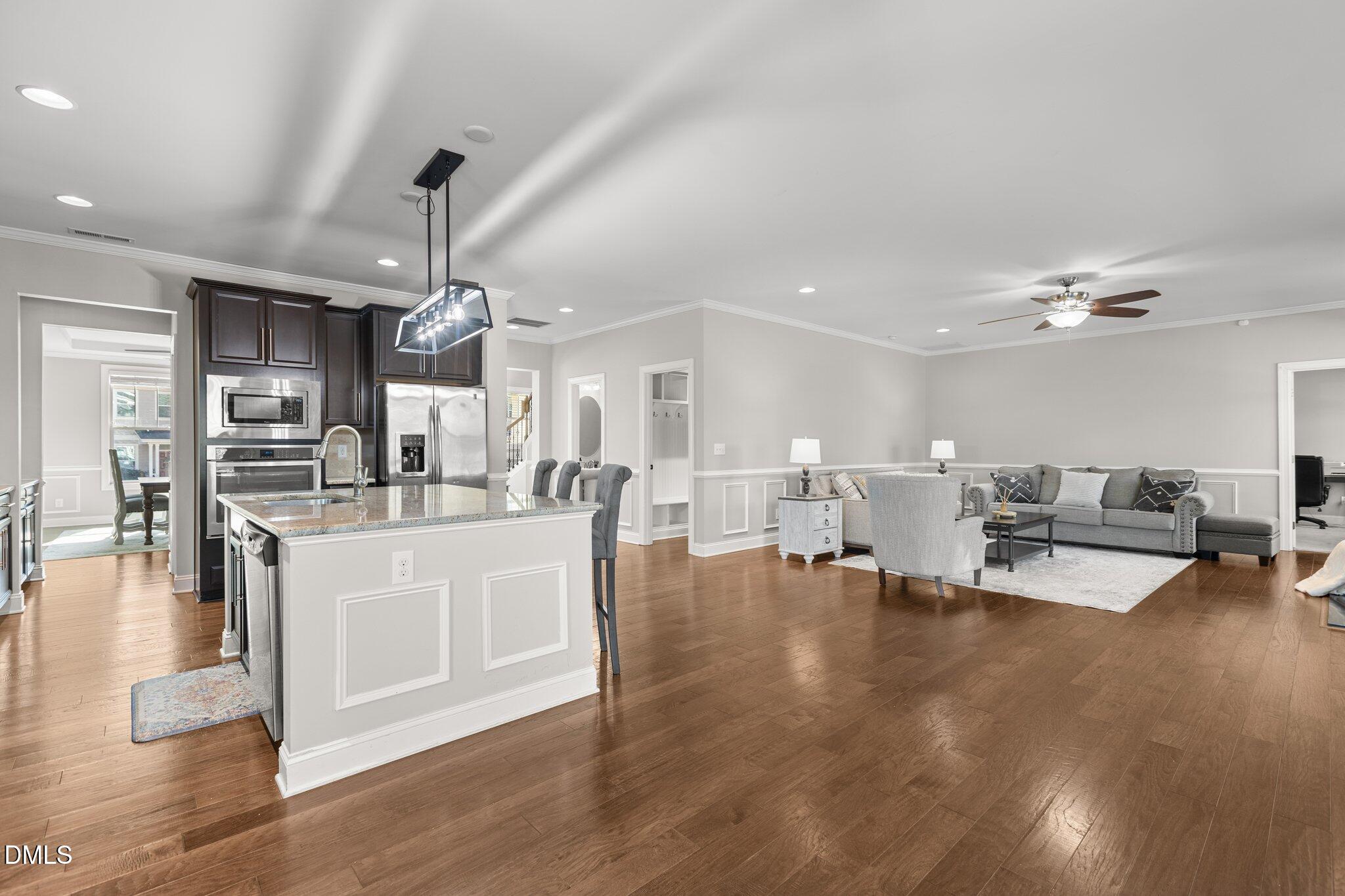 104 Highland Mist Circle Apex, NC 27539 - Photo 14 of 49 a large white kitchen with living room and couches chair