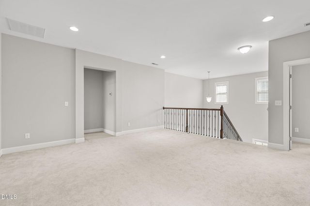a view of an empty room with a chandelier fan