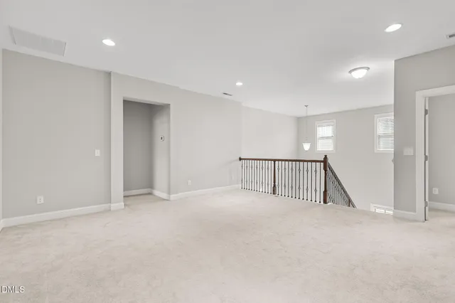 a view of an empty room with a chandelier fan