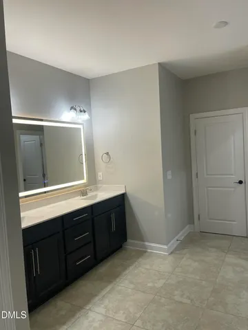 a spacious bedroom with a bed and a chandelier