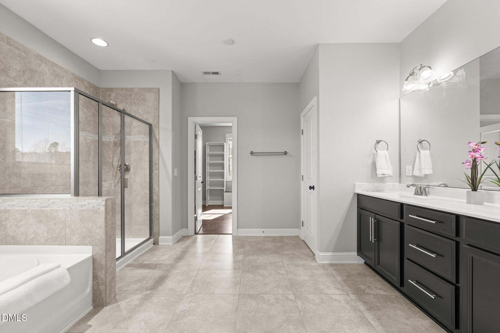 104 Highland Mist Circle Apex, NC 27539 - Photo 35 of 49 a bathroom with a tub sink and mirror