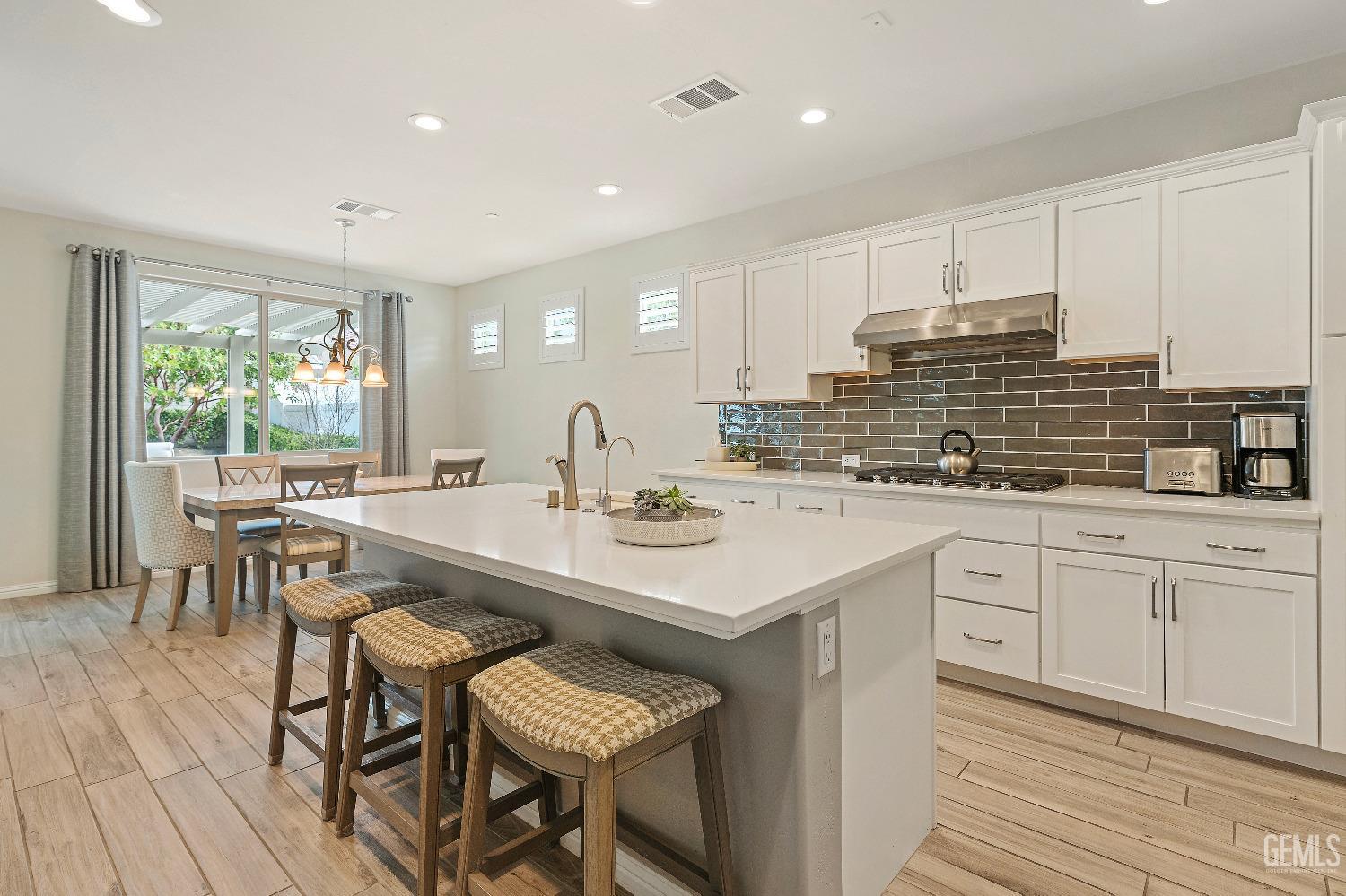 Undisclosed Address Bakersfield, CA 93311 - Photo 7 of 25 a kitchen with center island table and chairs
