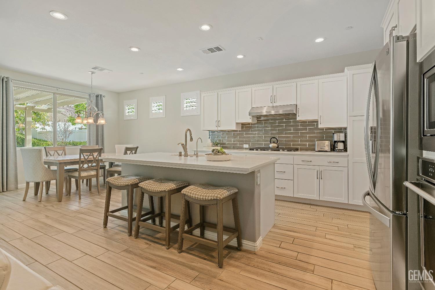 Undisclosed Address Bakersfield, CA 93311 - Photo 8 of 25 a kitchen with stainless steel appliances granite countertop a table chairs sink refrigerator and cabinets