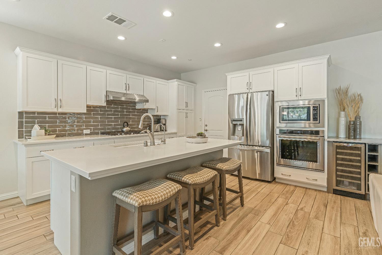 Undisclosed Address Bakersfield, CA 93311 - Photo 9 of 25 a kitchen with stainless steel appliances granite countertop a refrigerator a stove and a wooden cabinets with wooden floor