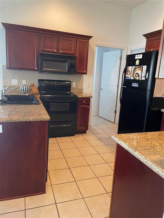 9311 Villa Entrada New Port Richey, FL 34655 - Photo 11 of 16 a kitchen with wooden cabinets and a stove top oven