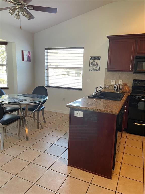 9311 Villa Entrada New Port Richey, FL 34655 - Photo 12 of 16 a kitchen with granite countertop sink cabinets and stove