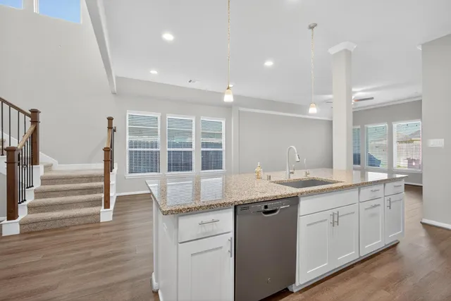 a kitchen with granite countertop white cabinets appliances a sink and a counter top