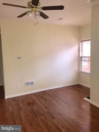 an empty room with a window and a ceiling fan