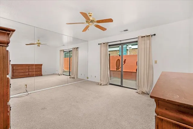 a view of an empty room with a ceiling fan