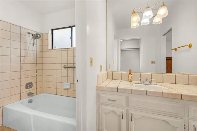 a bathroom with a tub sink and mirror